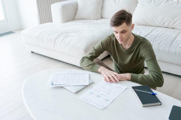 Man,Is,Sitting,At,A,Table,With,Papers,And,A