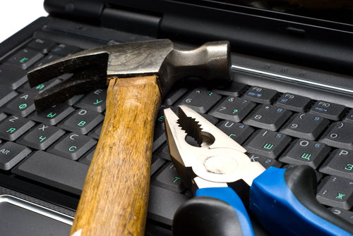 hammer and pliers on a laptop