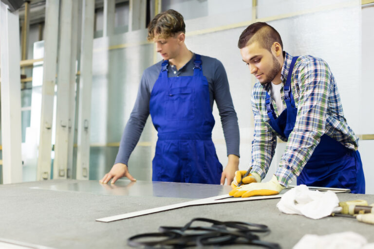 Two,Workers,Cutting,Glass,For,Windows,At,Workshop