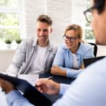 Financial,Consultant,Explaining,New,Project,Investment,To,Young,Couple,In
