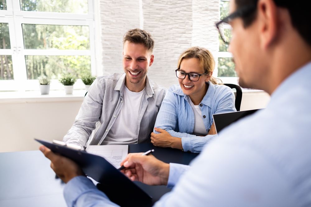 Financial,Consultant,Explaining,New,Project,Investment,To,Young,Couple,In