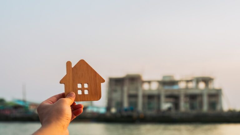 Investors,Hold,Up,A,Model,Of,A,Wooden,House,At