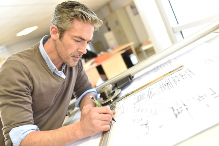 Architect,Working,On,Drawing,Table,In,Office