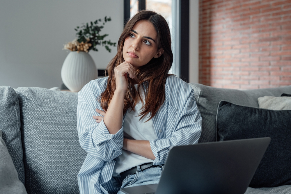 Distracted,From,Work,Worried,Young,Woman,Sitting,On,Couch,With