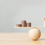 Wooden,Home,And,Money,Coins,Stack,On,Wood,Scale.,Property