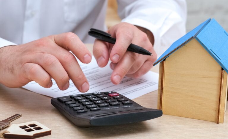 Man,Calculating,Mortgage,Payment,,Insurance,Or,Property,Tax,On,Calculator