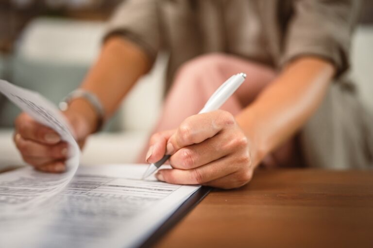 Close,Up,Of,Woman,Hands,Sign,Document