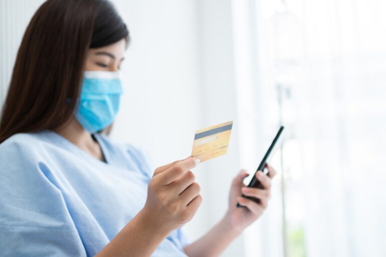 Happy,Asian,Woman,Wearing,A,Medical,Mask,And,Holding,Mock