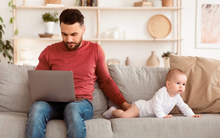 Young,Father,With,Baby,Using,Laptop,Browsing,Internet,Working,Online
