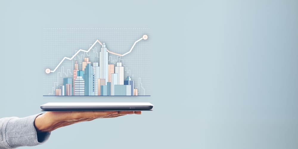 A,Hand,Holding,A,Tablet,With,A,Digital,City,Skyline