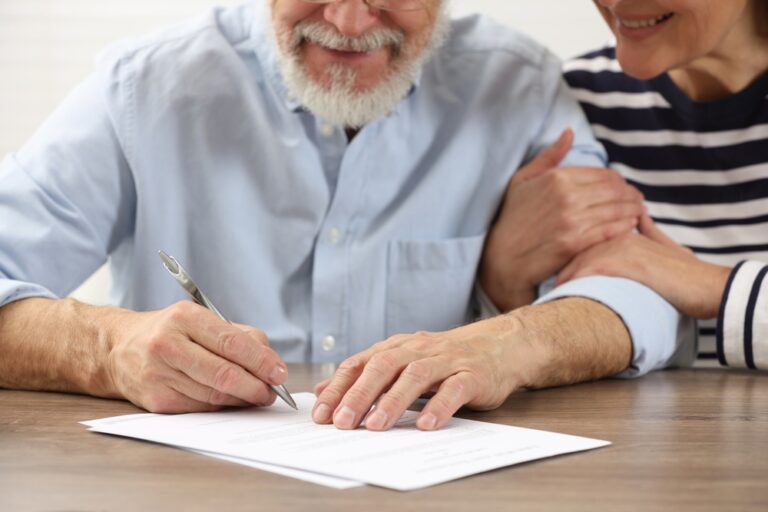 Senior,Couple,Signing,Last,Will,And,Testament,At,Wooden,Table,
