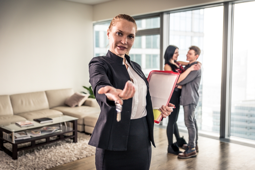 Real,Estate,Agent,And,Young,Couple,Making,Business,Deals,For