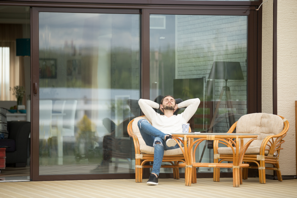 Young,Calm,Man,Relaxing,Sitting,On,Terrace,Chair,Hands,Behind