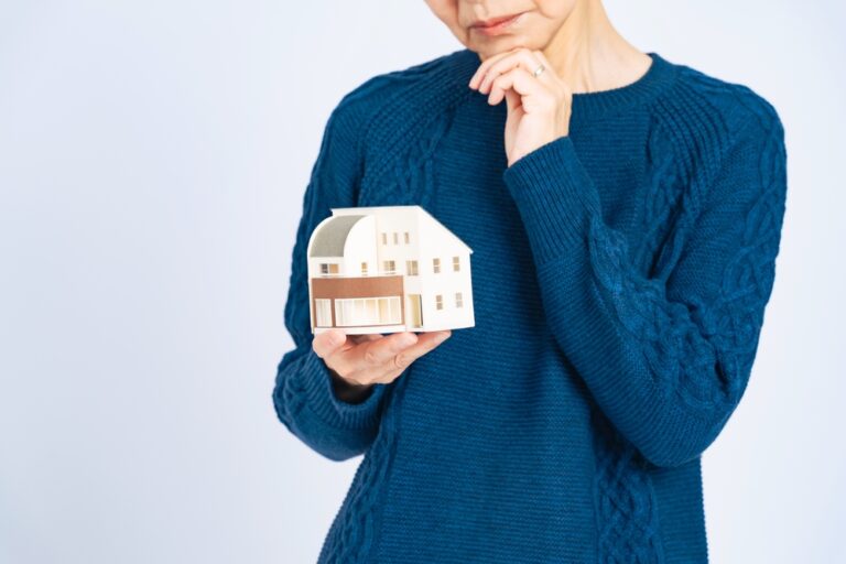 A,Worried,Senior,Woman,Holding,A,Model,House