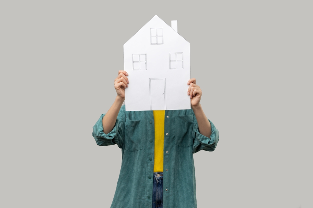 Unknown,Woman,Hiding,Face,Behind,Paper,House,With,Drawn,Windows