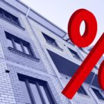 Large,Red,3d,Percentage,Sign,On,New,Multi-story,Residential,Building