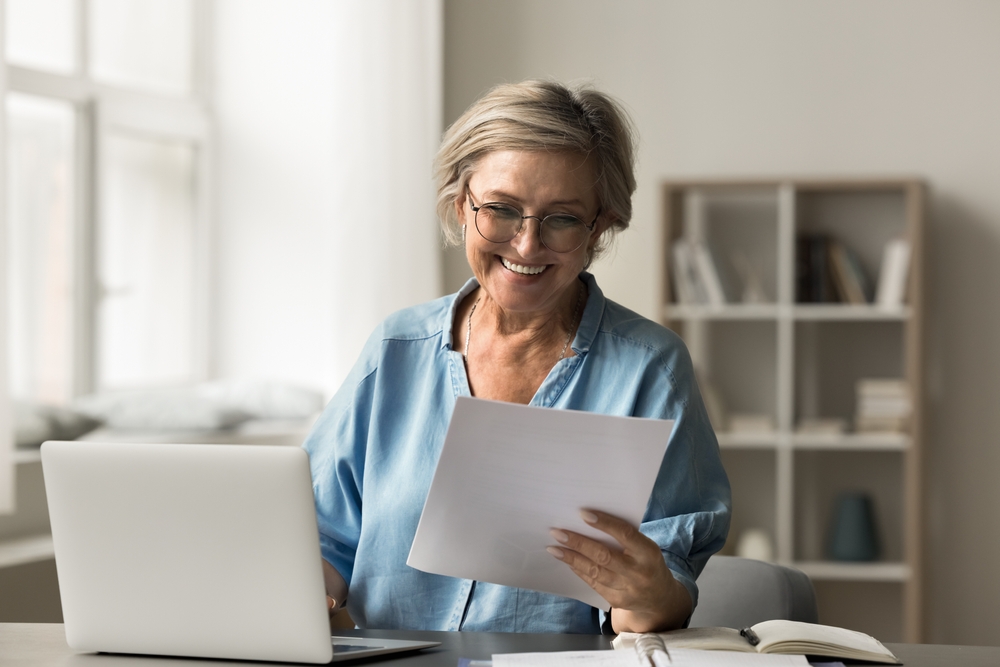 Mature,Woman,Read,Document,That,Confirms,Good,News,,Financial,Approval,