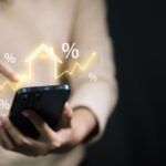 Smartphone,Users,Display,Glowing,House,Symbols,And,Percentages,,Representing,Mortgage