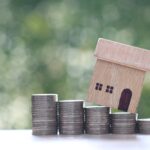 Mortgage,model,House,And,Stack,Of,Coins,Money,On,Natural,Green