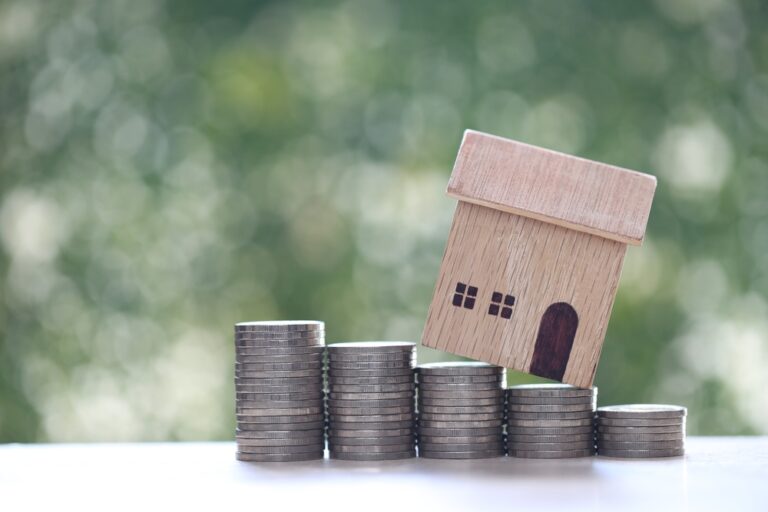 Mortgage,model,House,And,Stack,Of,Coins,Money,On,Natural,Green