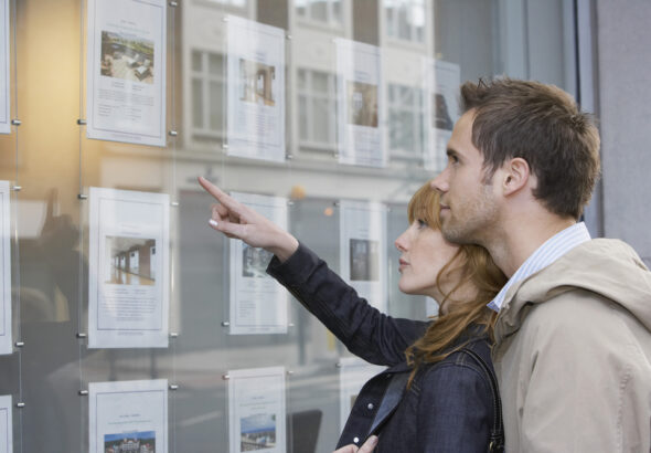 Side,View,Of,A,Young,Couple,Looking,At,Window,Display