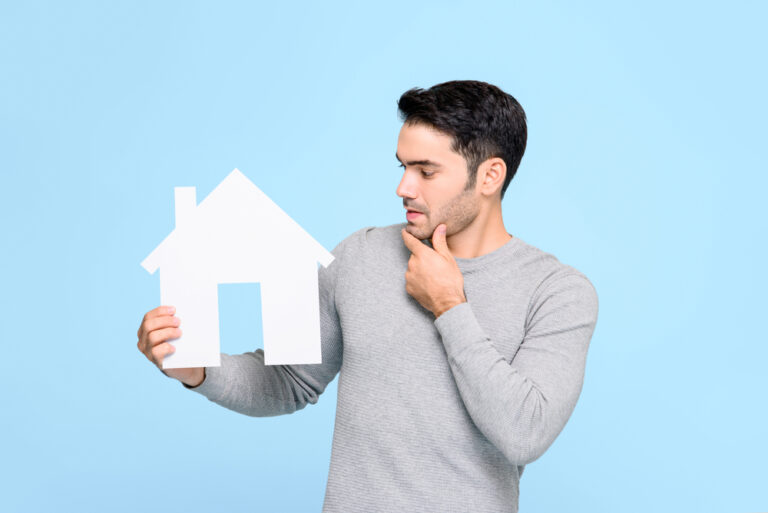 Young,Man,Looking,At,House,Model,And,Thinking,Isolated,On