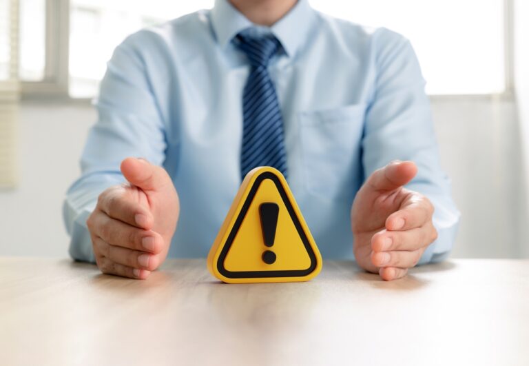 Warning,Sign,In,Businessman's,Hand,,Caution,In,Investing,Economic,Situation