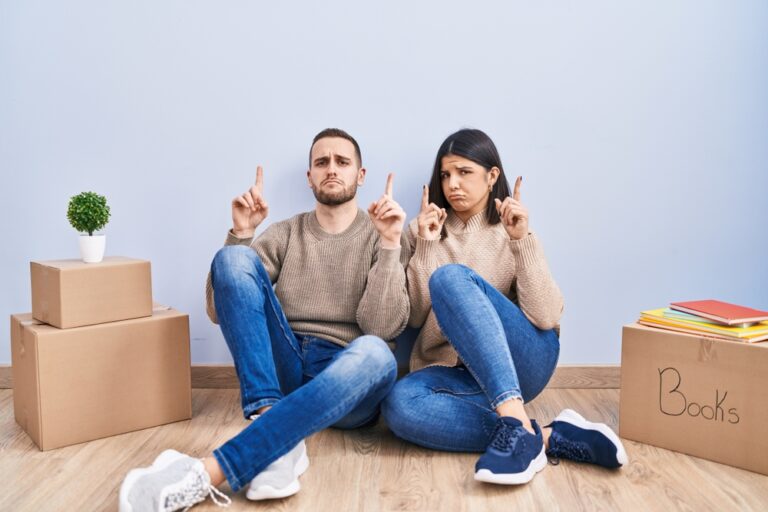 Young,Couple,Moving,To,A,New,Home,Pointing,Up,Looking