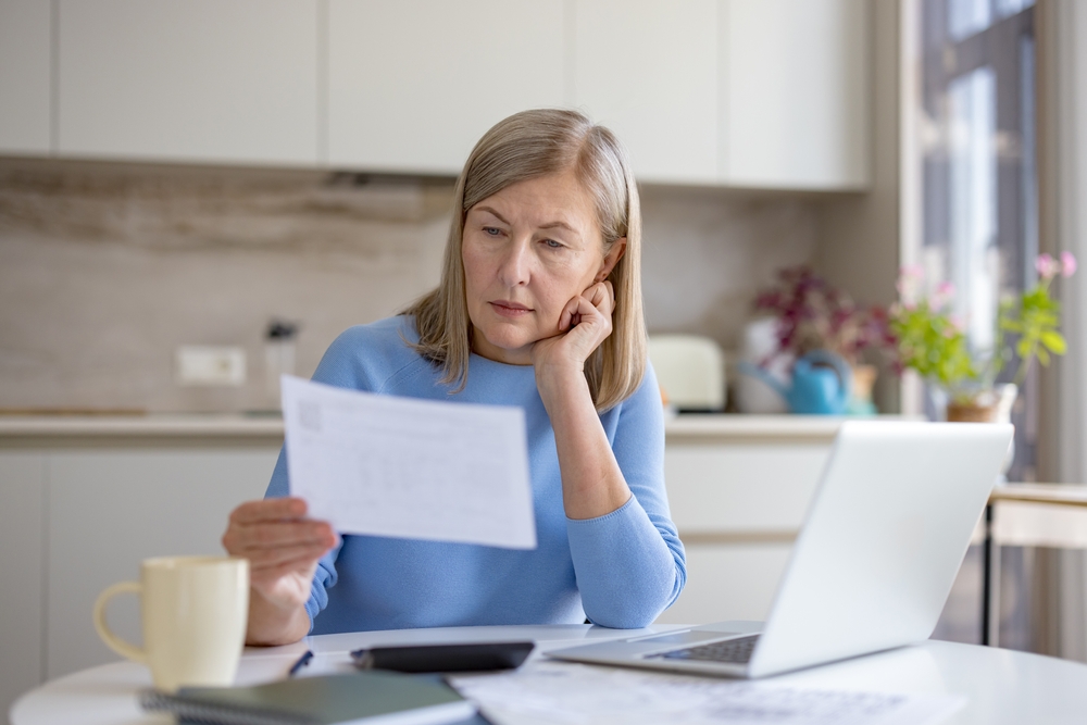 Mature,Woman,Analyzing,Financial,Documents,And,Bills,,Calculating,Expenses,,And