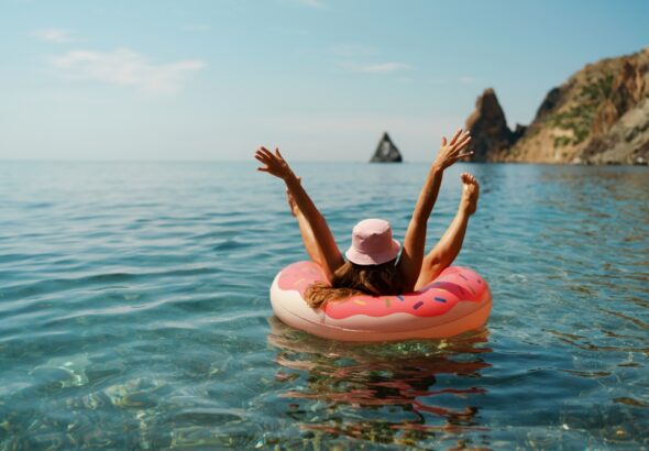 Summer,Vacation,Woman,In,Hat,Floats,On,An,Inflatable,Donut