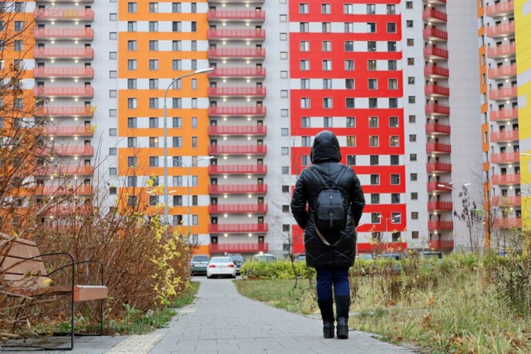 Lonely,Woman,In,Black,Leather,Coat,Standing,On,Apartment,Building