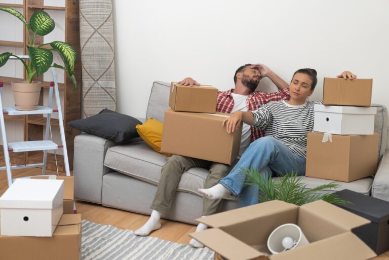 Tired,Man,And,Woman,Relaxing,On,Sofa,After,Carrying,Packed