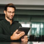 Smiling,European,30s,Trade,Manager,Looking,At,Digital,Tablet,Screen