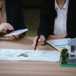 Business,Professionals,Discussing,A,House,Model,With,Documents,And,Calculator