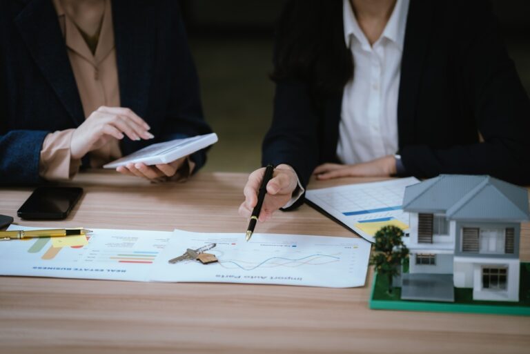 Business,Professionals,Discussing,A,House,Model,With,Documents,And,Calculator