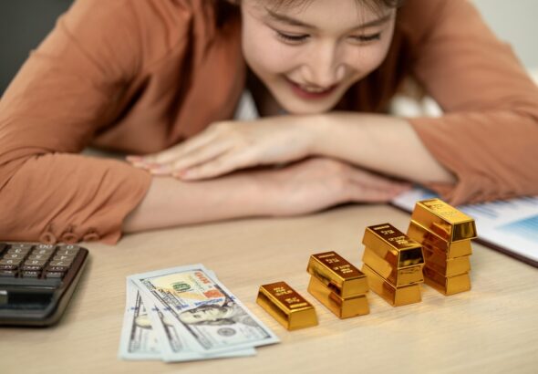 Adult,Asian,Female,Happily,Analyzes,Gold,Investments,Dollars,Calculator,Business