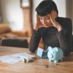 Woman,Stressed,Over,Bills,And,Finances,At,Home,,Sitting,By