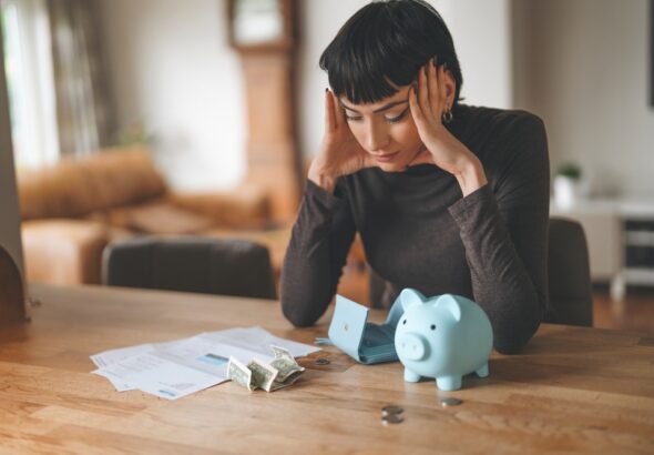 Woman,Stressed,Over,Bills,And,Finances,At,Home,,Sitting,By