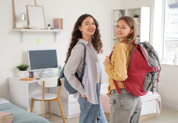 Female,Students,With,Backpacks,In,Dorm,Room