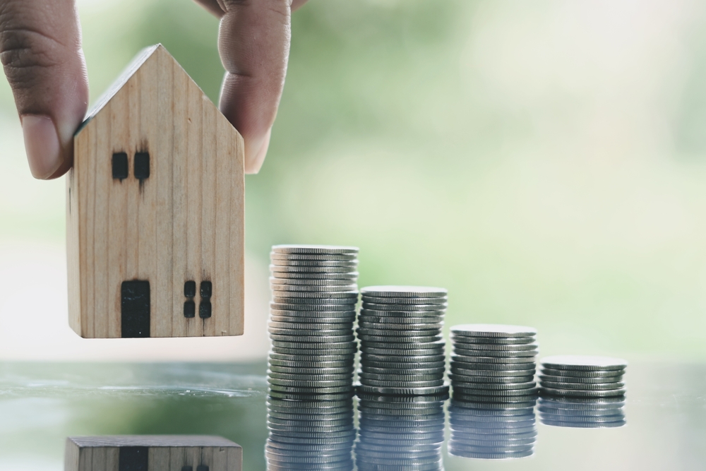 Close,Up,Stack,Of,Coin,And,Toy,Wooden,House,On