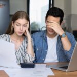 Concerned,Young,Couple,Of,Tenants,,Renters,Checking,Too,High,Paper