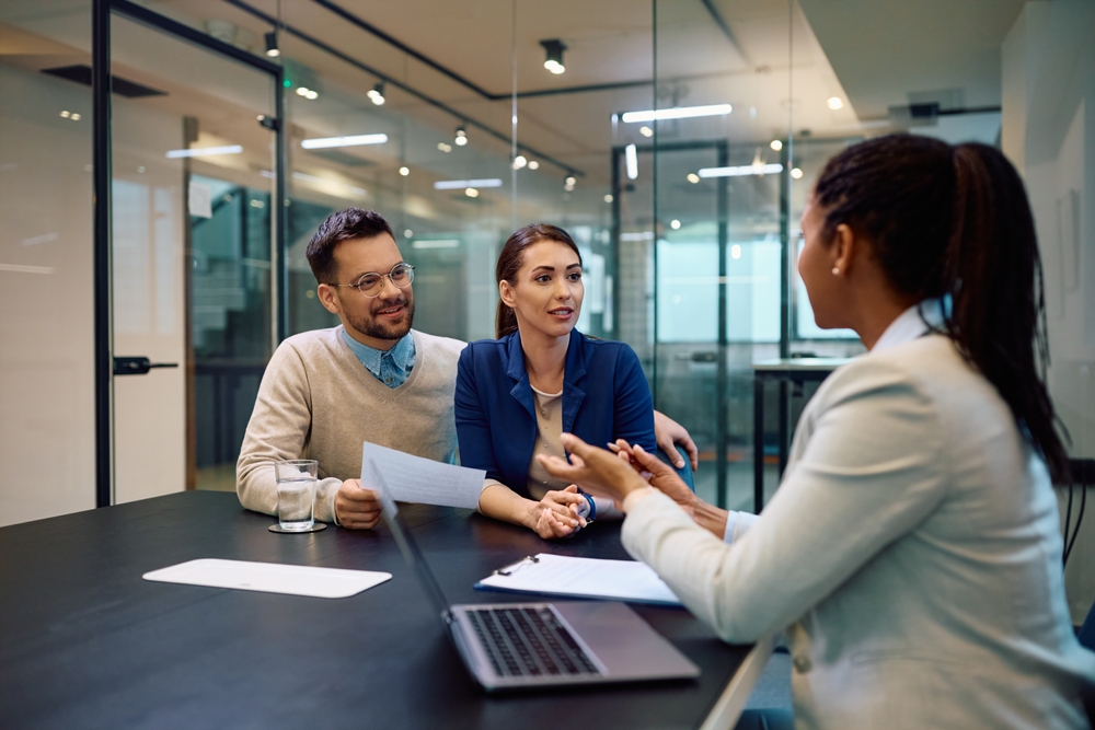 Young,Couple,Talking,To,Their,Financial,Advisor,During,A,Meeting