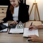 Real,Estate,Consultant,Using,Calculator,To,Discuss,Housing,Finance,With
