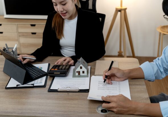 Real,Estate,Consultant,Using,Calculator,To,Discuss,Housing,Finance,With