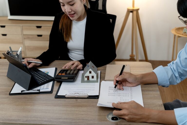 Real,Estate,Consultant,Using,Calculator,To,Discuss,Housing,Finance,With